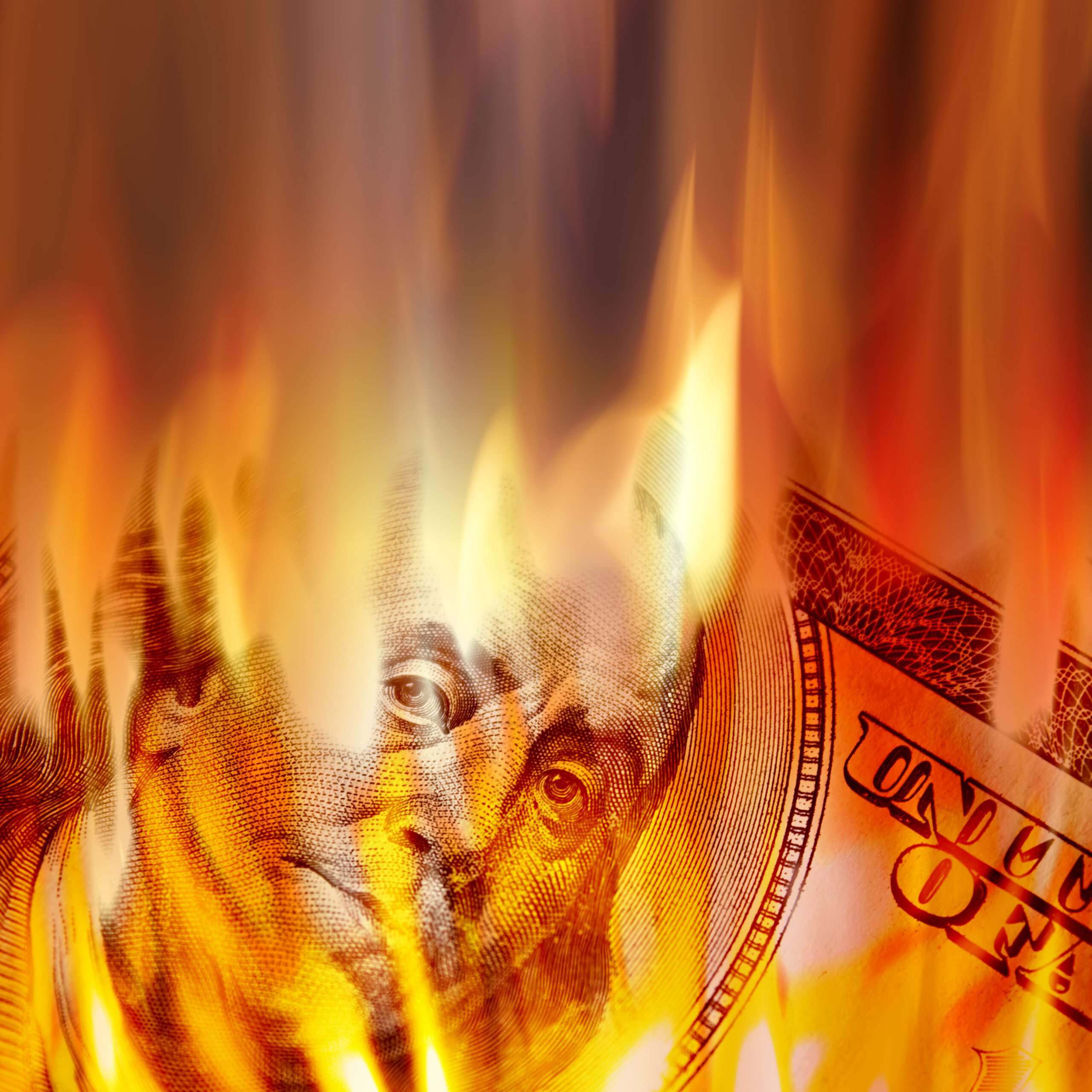 burning american money with benjamin franklins face appearing on fire on a one hundred dollar bill StjeH9P0Ss scaled